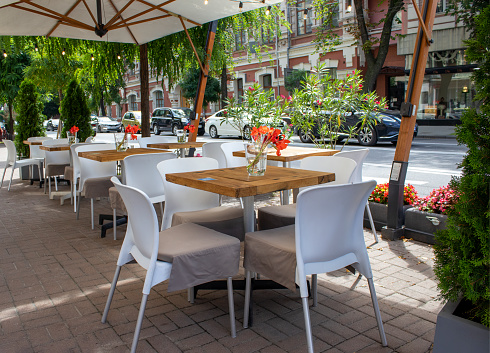 Image of Elegant Restaurant tables in row terrace and rustic grey stone street background