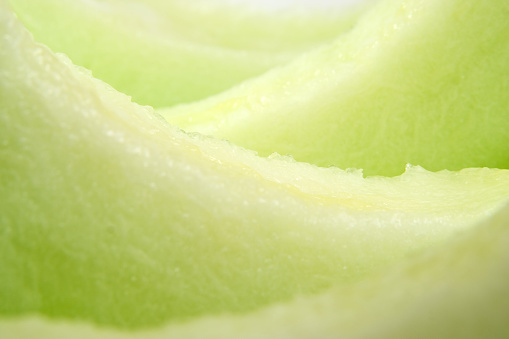 Honeydew melon slices up close and in abstract. 