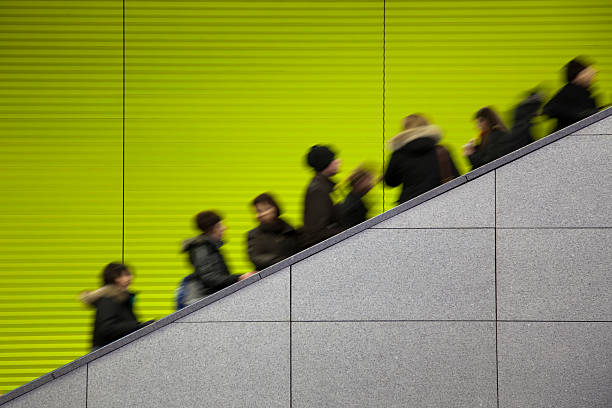 istock Commuters moving on escalator against a green background 157531688