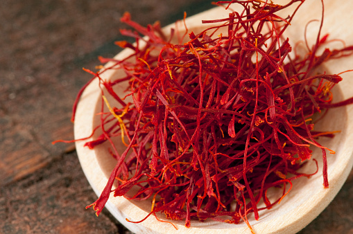 A wooden spoonful of bright red saffron