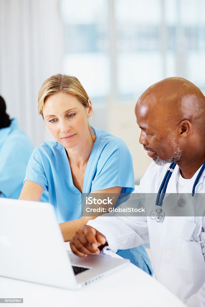 Make and female doctor working on a white laptop Doctors working on a laptop in hospital Doctor Stock Photo