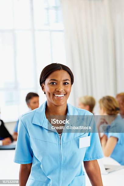 Foto de Enfermeira Americana Sorrindo Com Colegas De Trabalho Em Uma Reunião Para Trás e mais fotos de stock de 20 Anos