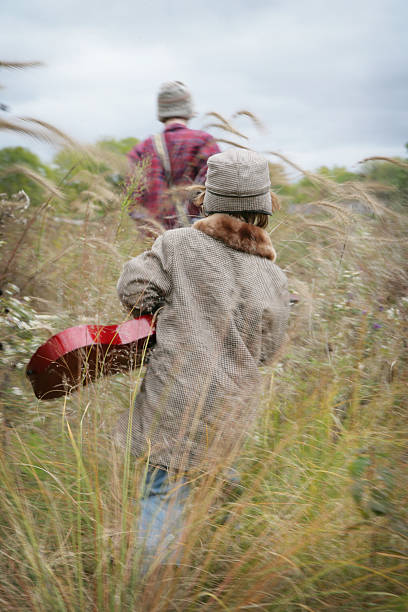 niños caminando a través de hierba con guitars prairie - parker brothers fotografías e imágenes de stock