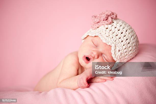 Sleeping Newborn Baby Girl Wearing A Crocheted Hat On Pink Stock Photo - Download Image Now