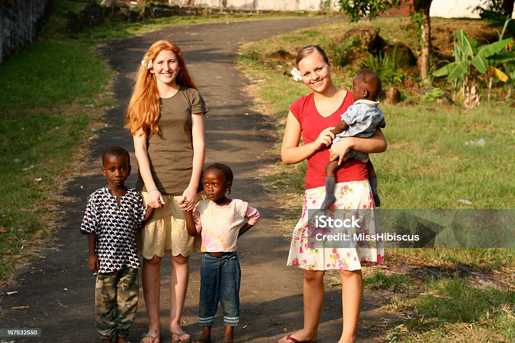 American adolescentes com crianças africanas - Foto de stock de Orfanato - Edifício público royalty-free