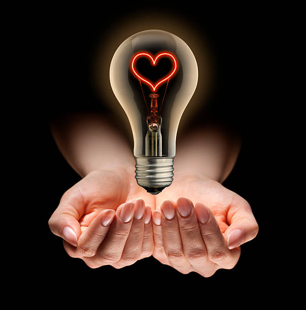 istock Light of Love, Hands Holding Floating Red Heart Shaped Bulb 157532568