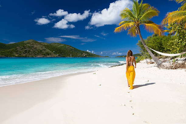woman walking on the beach stock photo