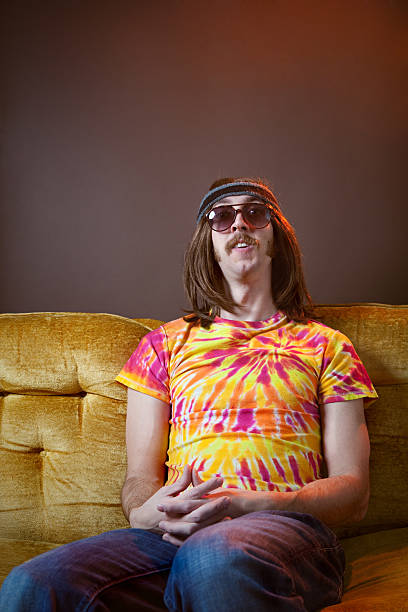 hippy homem sentado no sofá vintage - fashion men 1970s style hippie imagens e fotografias de stock