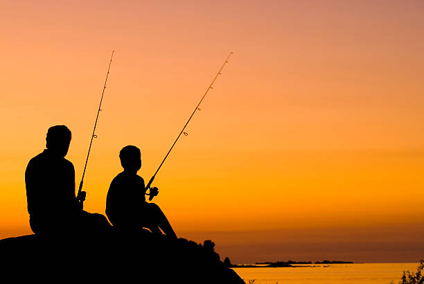 pequeno menino e o avô pesca ao pôr do sol-iii - fishing active seniors family senior adult imagens e fotografias de stock