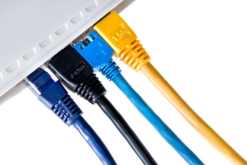 close up of plugged-in lan cable in a home router/switch, isolated on white