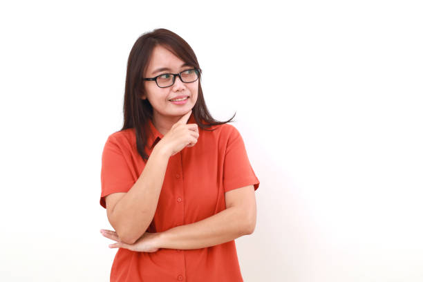istock Happy asian woman standing while looking sideways on blank space 1575329441