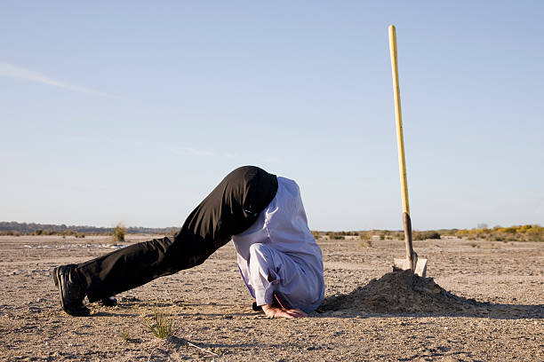 Denial A concept of denial or a refusal to see truth using humour to bring the message. A man with his head in a hole. head in the sand stock pictures, royalty-free photos & images