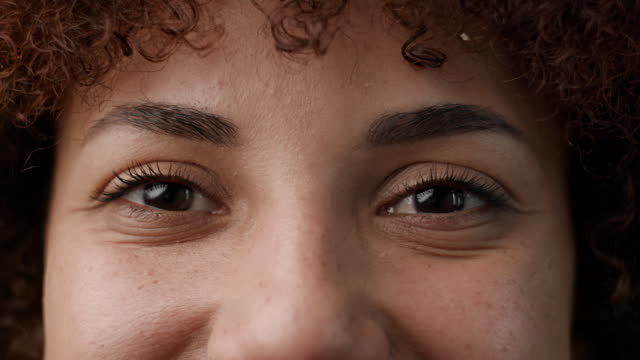 African American Female Eyes Opening Close Up. Smiling black woman looking at camera.