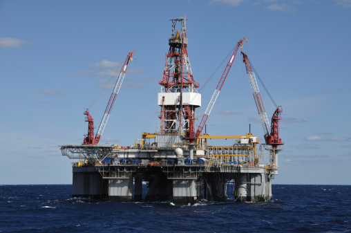 A floating deep water semi-submersible oil drilling on location at sea. An anchored oil rig.