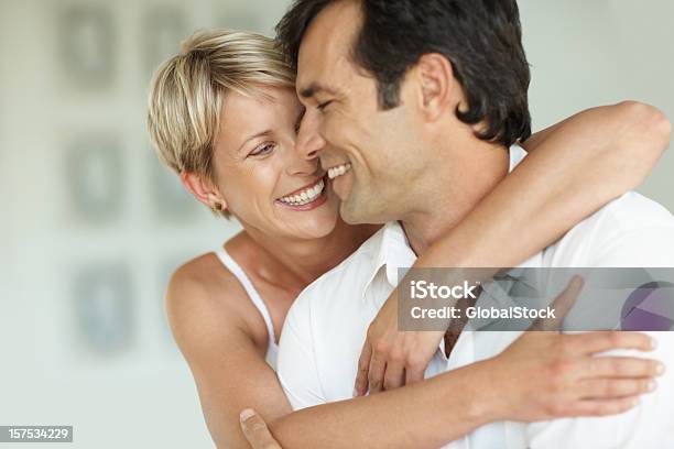 Metà Età Donna Felice Abbracciare Il Marito - Fotografie stock e altre immagini di 35-39 anni - 35-39 anni, 40-44 anni, Abbigliamento casual