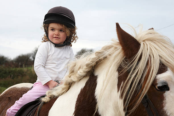 istock Cute three year old girl first horseriding lesson 157534309