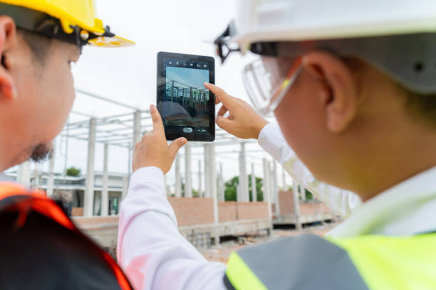 istock Home building engineers discuss plans with contractors via online system on a tablet. and take pictures at the event 1575392518