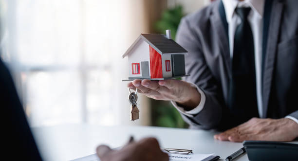 agent de courtier immobilier présentant et consultant au client à la prise de décision signer l'accord de forme d'assurance, modèle à la maison, concernant l'offre de prêt hypothécaire pour et l'assurance de maison - real estate agent photos et images de collection