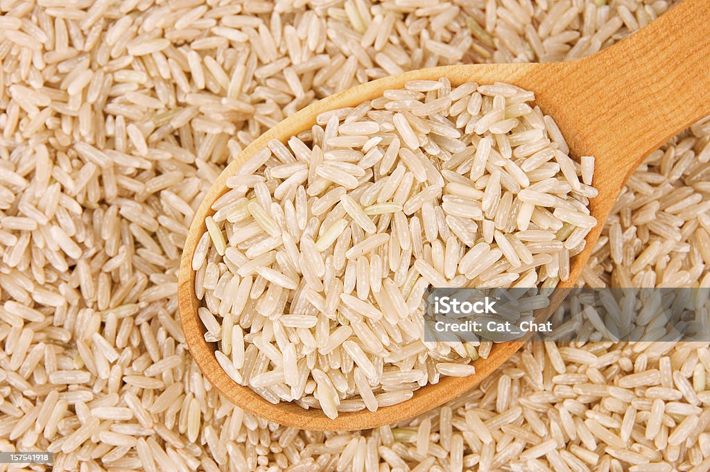 Brown rice Raw brown rice in wooden spoon on rice background Brown Stock Photo