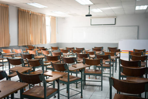 istock Empty classroom with vintage tone wooden chairs. Back to school concept 1575447630