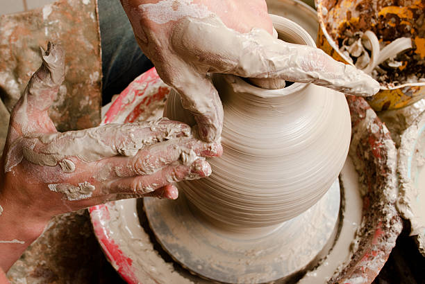 istock hands of a potter, creating an earthen jar 157545045