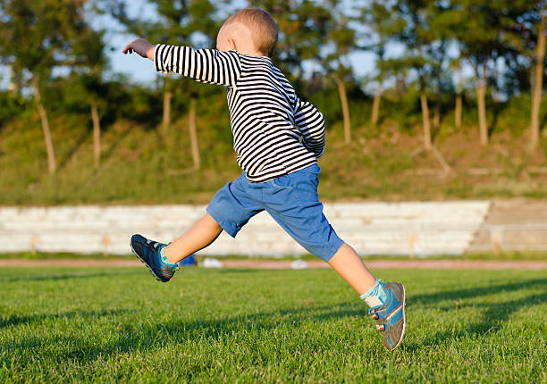 istock Little boy midair kicking a ball 157546562