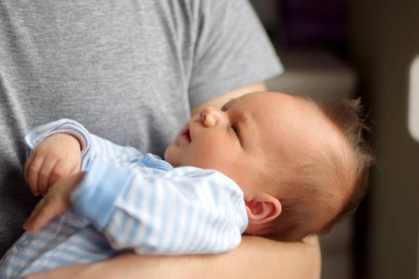 istock Man holding newborn baby boy 1575560127