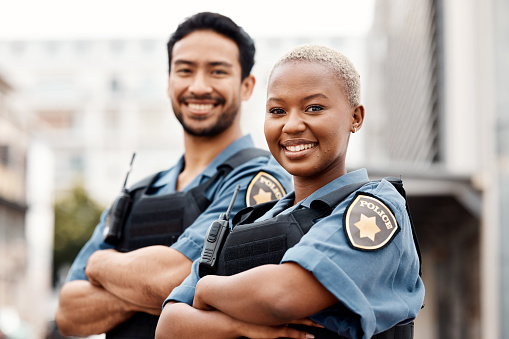 Happy police, team and arms crossed in confidence for city protection, law enforcement or crime. Portrait of man and woman officer standing ready for justice, security or teamwork in an urban town