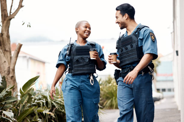 Police, conversation and team on a coffee break after investigation, walking and patrol for law protection in city. Criminal, happy and legal service guard or security smile for justice enforcement Police, conversation and team on a coffee break after investigation or patrol for law protection in city or town. Criminal, happy and legal service guard or security smile for justice enforcement police force smiling officer stock pictures, royalty-free photos & images