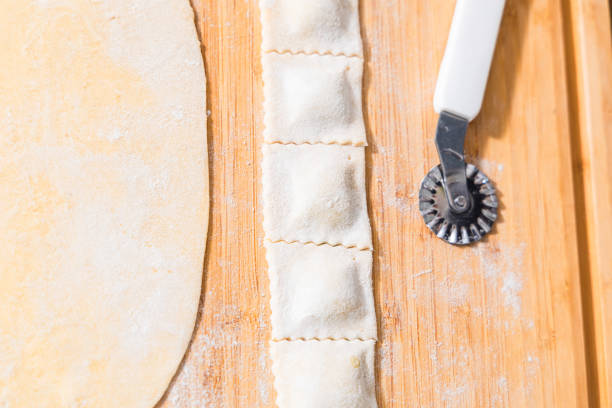 Hands Preparing ravioli with ricotta cheese and spinach. Fresh homemade pasta. Traditional Italian food.