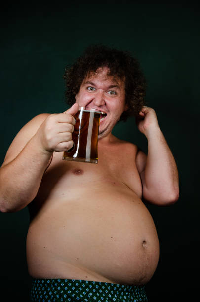 istock Funny fat man drinks beer on an Irish holiday. 1575579376