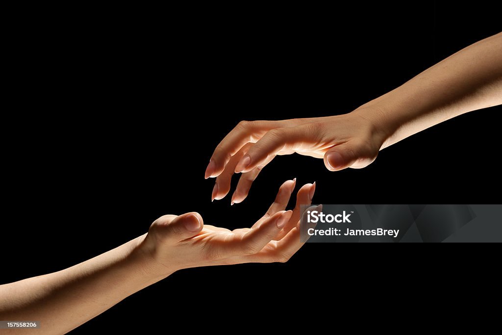 Due mani portata fuori In Darkness per mantenere un altro - Foto stock royalty-free di Tendere la mano