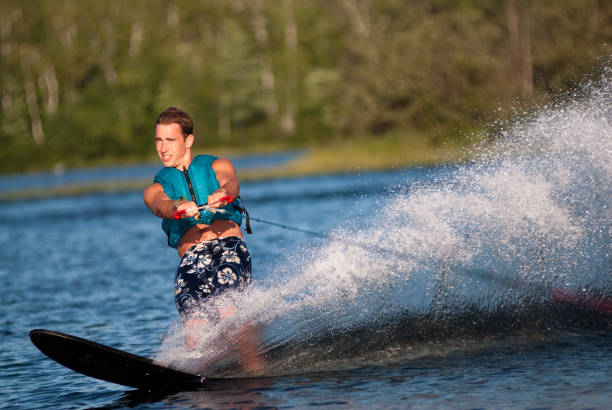 Waterskiing with man shredding waves stock photo