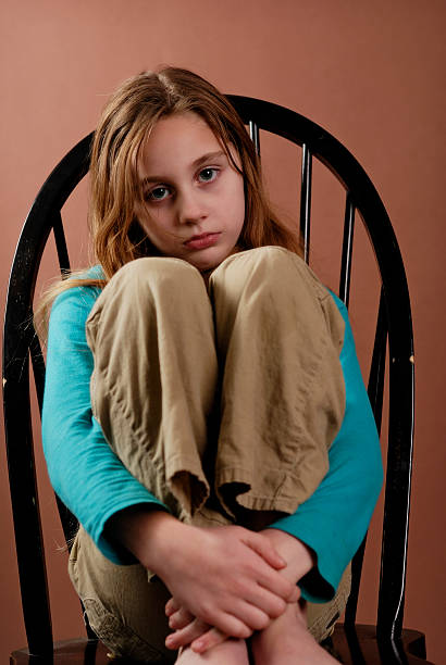 zwarzony lub smutna dziewczyna na krześle - zwarzony zdjęcia i obrazy z banku zdjęć