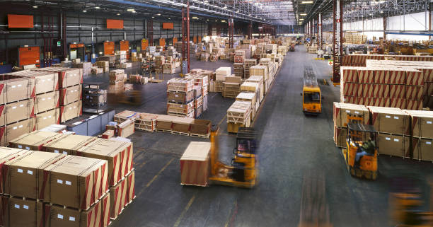 View from above inside a busy huge industrial warehouse Indoor manufacturing and storage detail factory forklift stock pictures, royalty-free photos & images