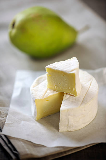 istock Camembert cheese and a pear on a table 157558819