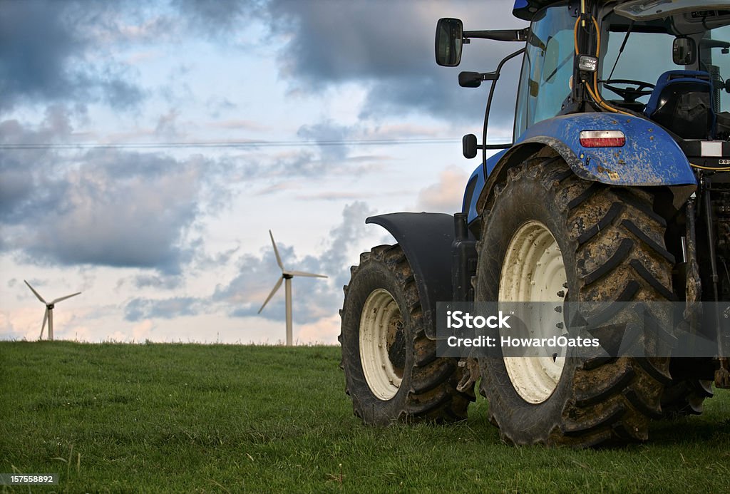 Trattore con fattoria di turbine a vento - Foto stock royalty-free di Trattore