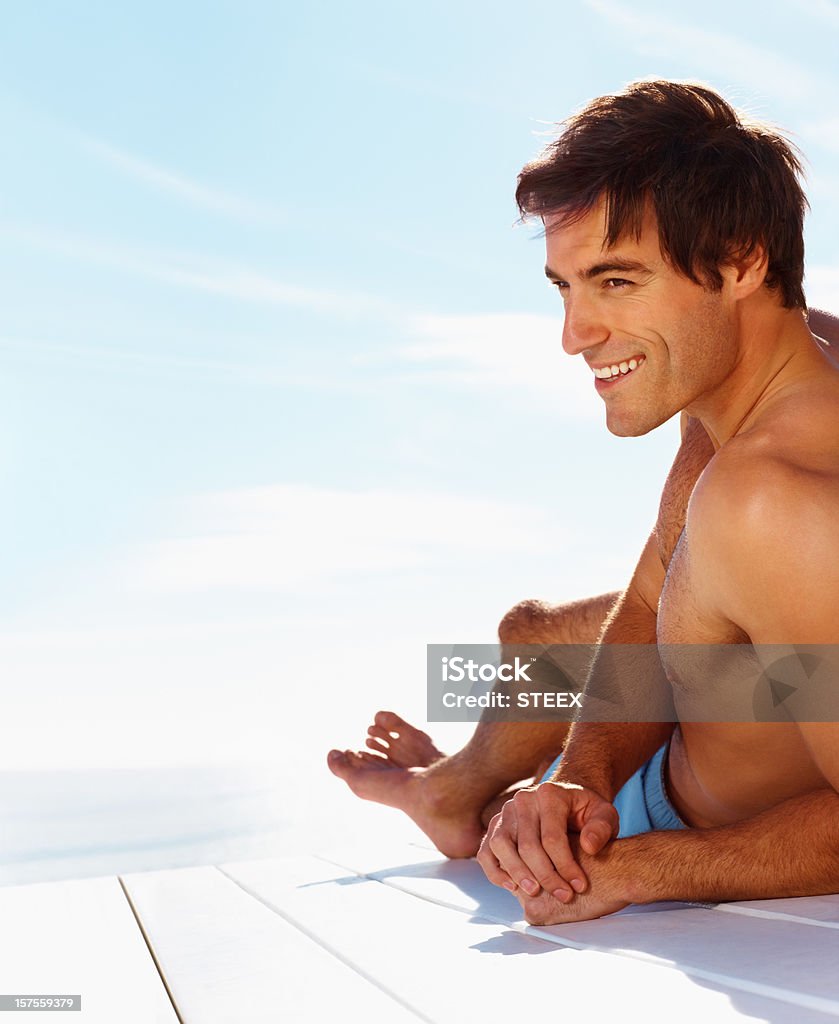 Smart young man smiling while relaxing outside  Men Stock Photo