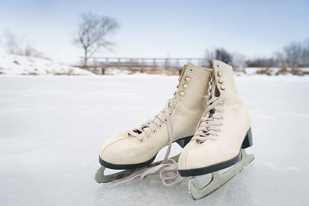 Woman lacing figure skates on ice, closeup