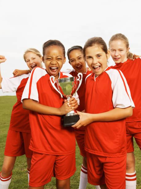 istock Young girls celebrating victory with a trophy 157559612