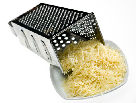 Grated cheese and old metal grater on which it was grated