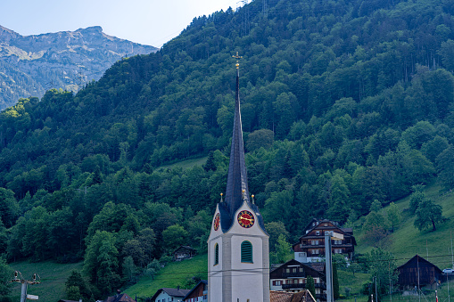Scenic view of Swiss village of Flüelen with church on a sunny spring morning. Photo taken May 22nd, 2023, Flüelen, Canton Uri, Switzerland.