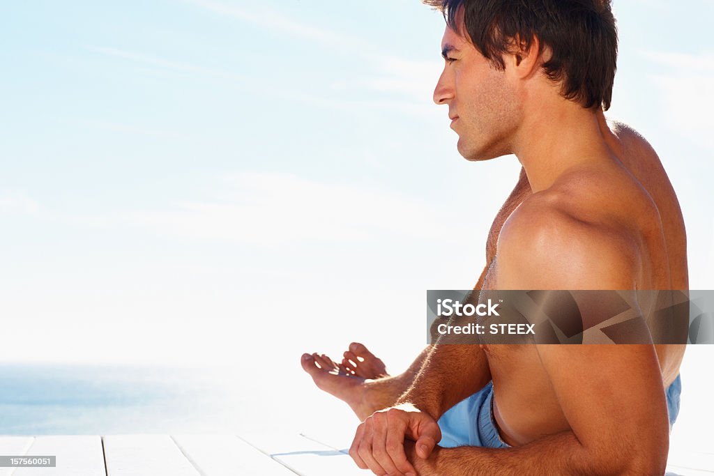 Młody człowiek relaksujący na morzu w słoneczny dzień - Zbiór zdjęć royalty-free (20-24 lata)
