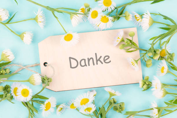 istock Thanks card surrounded by flowers, german language, being thankful, support, help and charity concept, positive attitude 1575601139