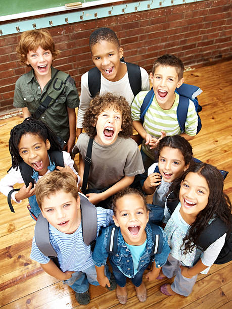 Top view of a group of elementary students looking upwards with their mouths opened