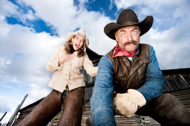 Group of young women throwing up their cowboy hats into the air while sitting on their horse.