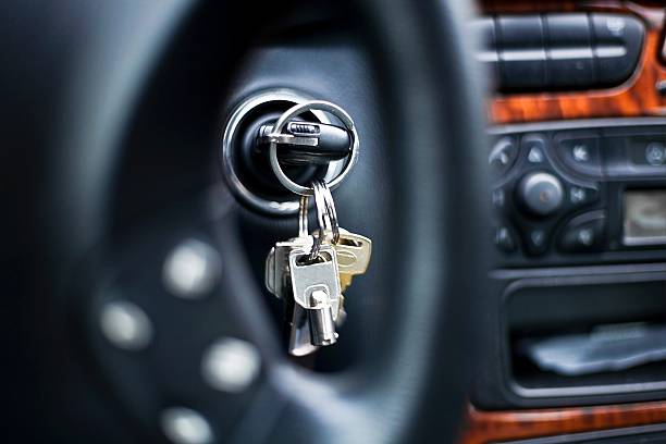 starting the car - car key in ignition lock starting the car, fokus trough the car whell of the starter key, shallow depth of field key ring stock pictures, royalty-free photos & images