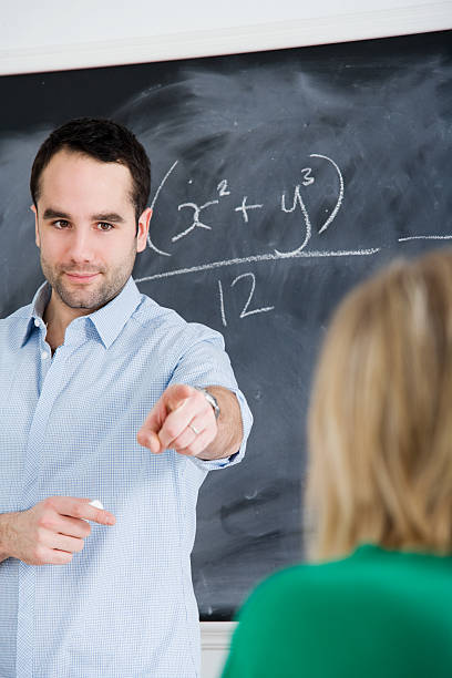 Male Teacher Pointing at Student stock photo