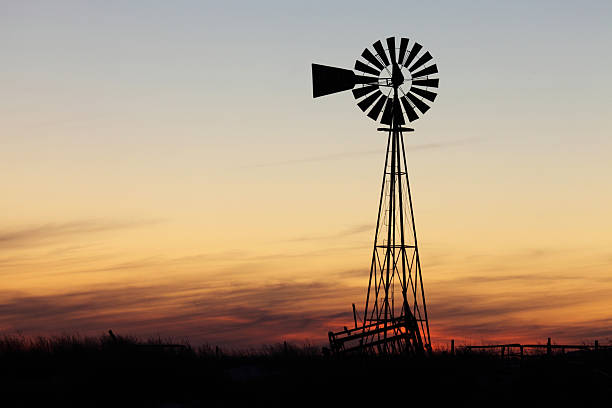Beautiful sunset and windmill Windmill silhouette against warm sunset and cloudscape. southwest usa photos stock pictures, royalty-free photos & images