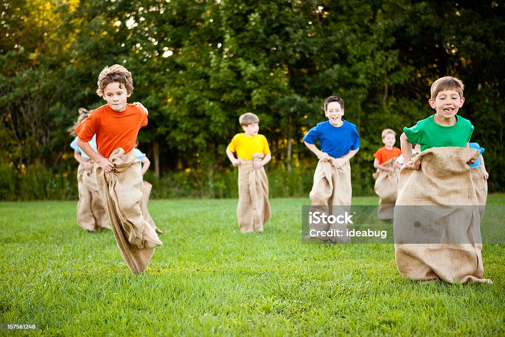 Szczęśliwy dzieci, uwzględniając zabawny ziemniak Wyścig w worku poza - Zbiór zdjęć royalty-free (Wyścig w worku)